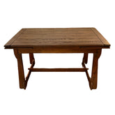 Wooden table with bench against a brick wall.