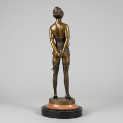 Bronze sculpture of a figure holding a rod against a textured wall.
