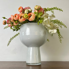 White vase with a bouquet of flowers on a wooden surface