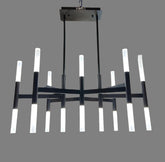 Modern chandelier hanging in a rustic interior setting with wooden beams and brick walls.