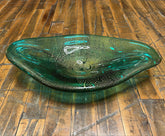Green glass bowl on a wooden floor
