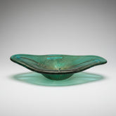 Green glass bowl on a wooden floor