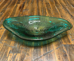 Green glass bowl on a wooden floor