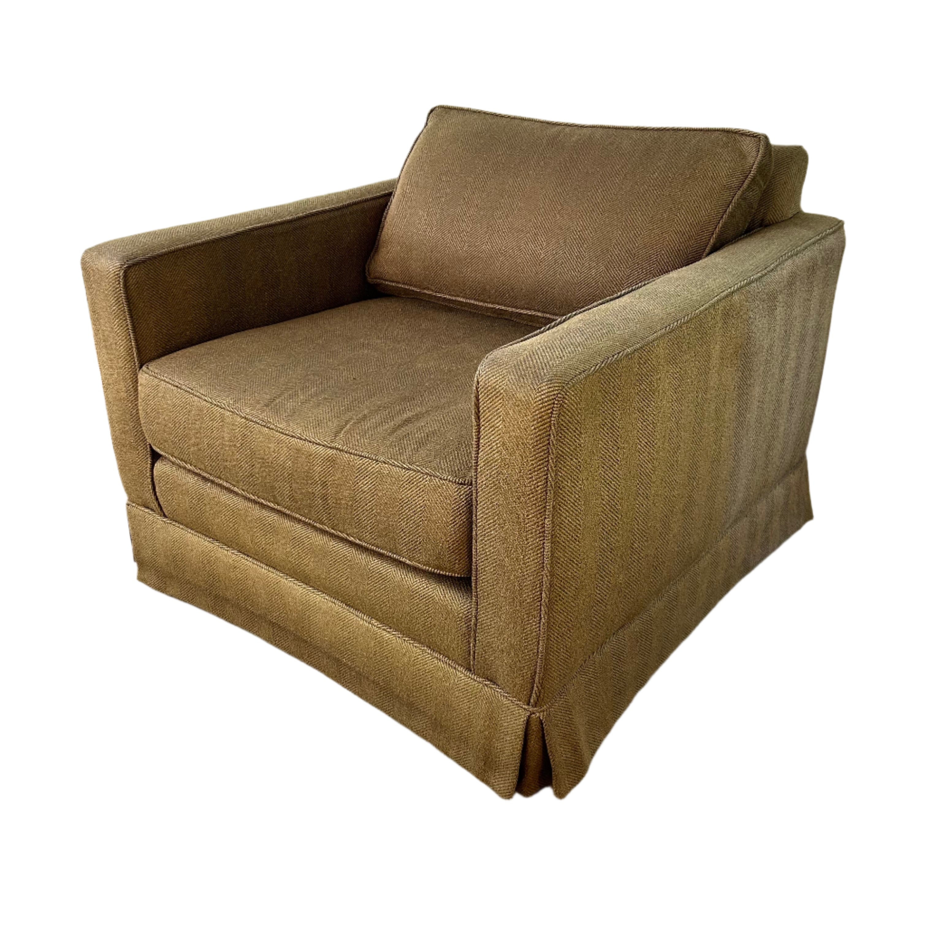 Brown upholstered chair on a concrete floor with a white wall background