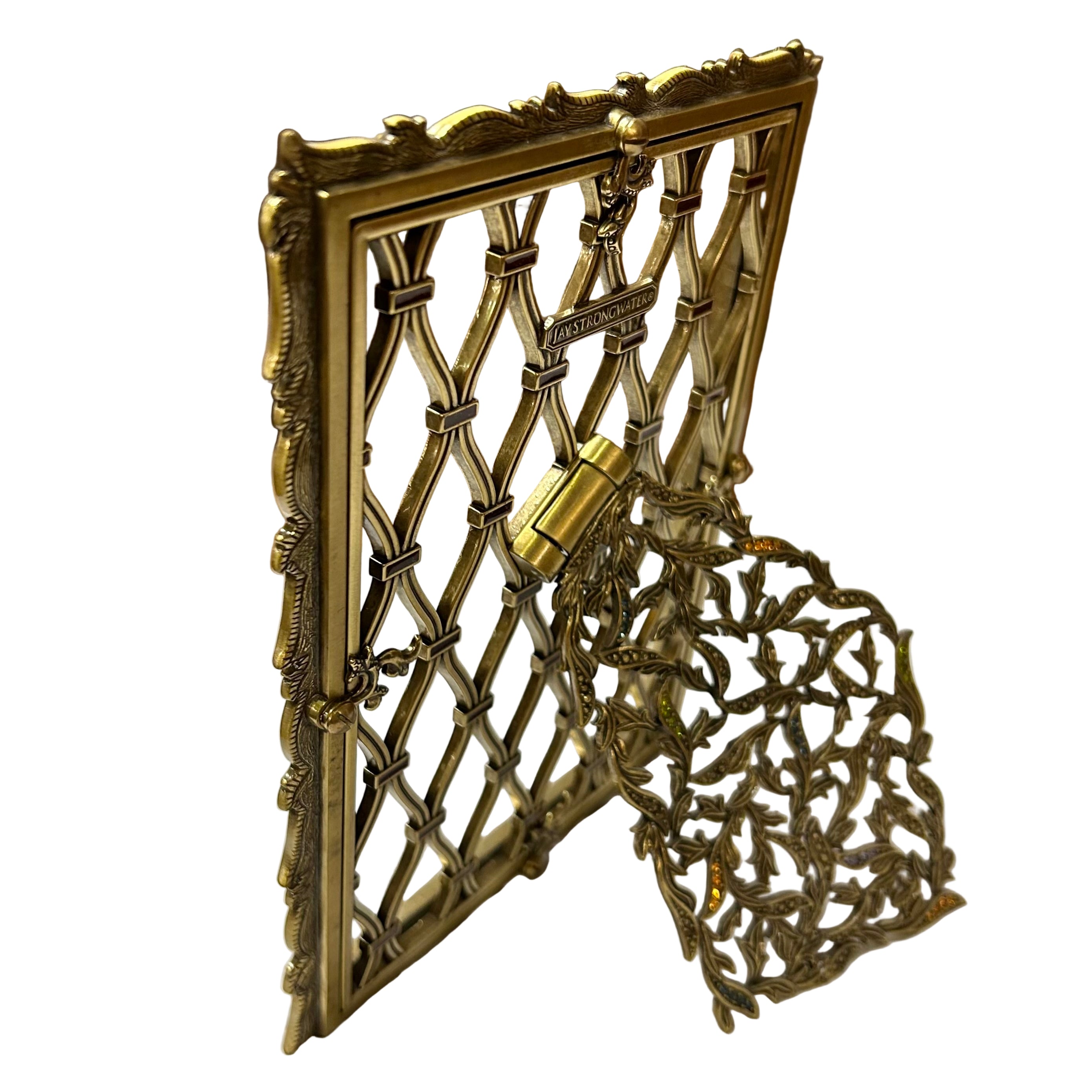 Decorative gold metal gate with intricate design on a white surface