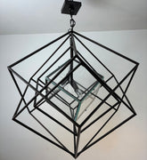Geometric black metal pendant light fixture on a plain background