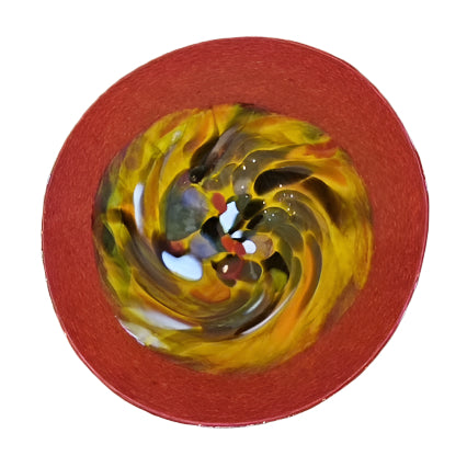 Colorful swirl design on a red plate against a wooden background