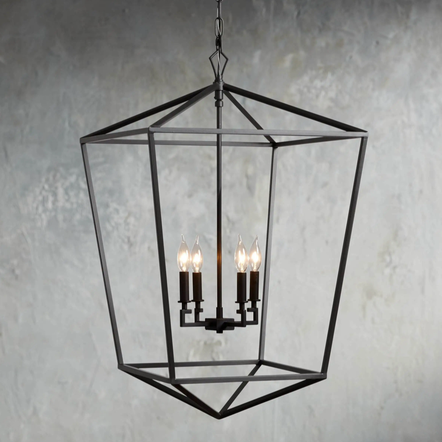 Decorative black chandelier with three lit lights against a textured gray wall.