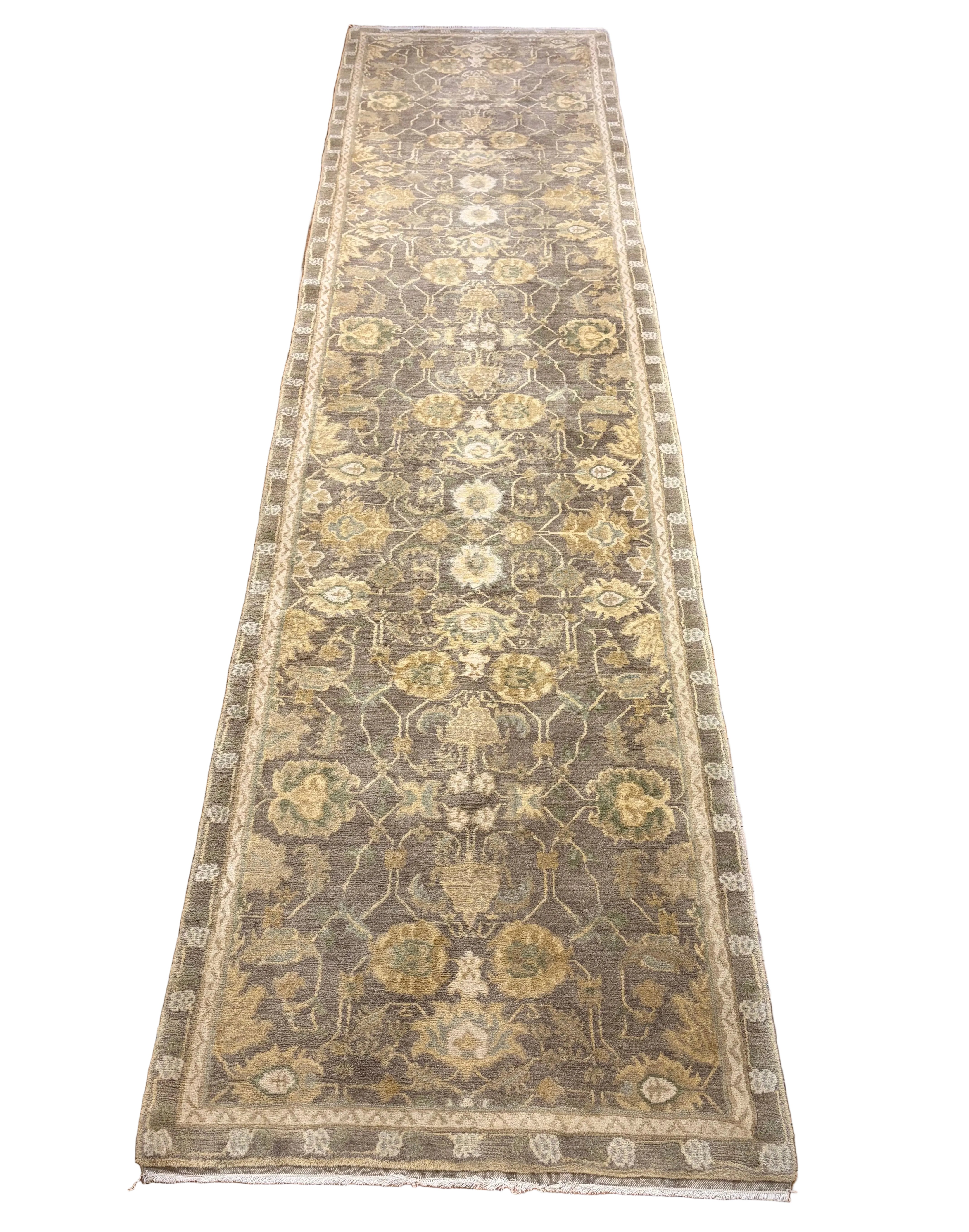 Long rectangular rug with intricate patterns on a wooden floor