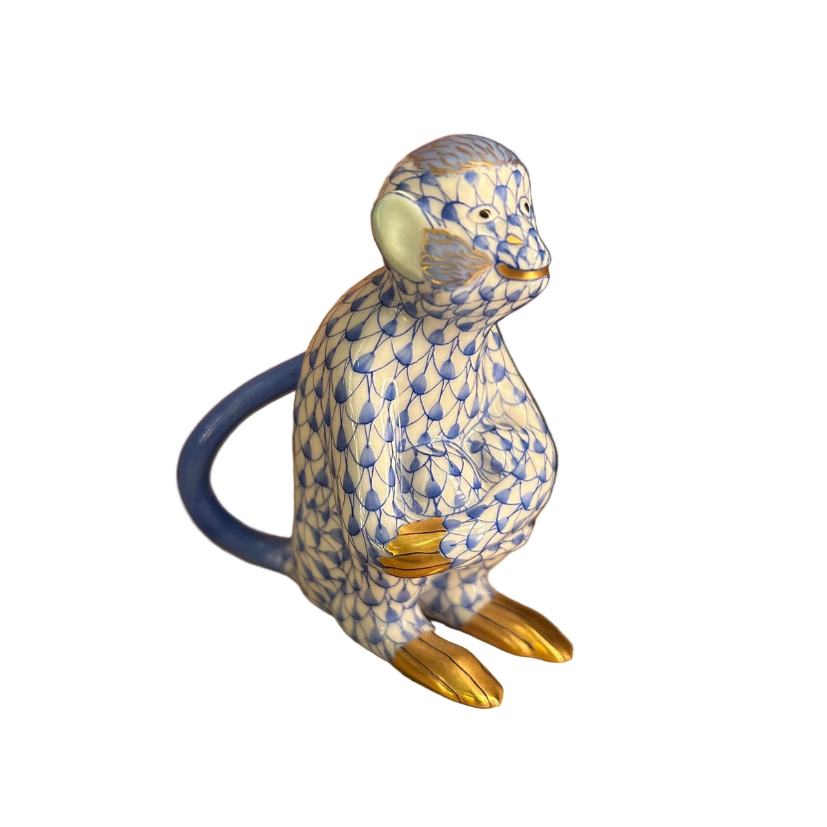 Decorative monkey figurine with blue and gold pattern on a beige surface