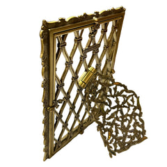 Decorative gold metal gate with intricate design on a white surface
